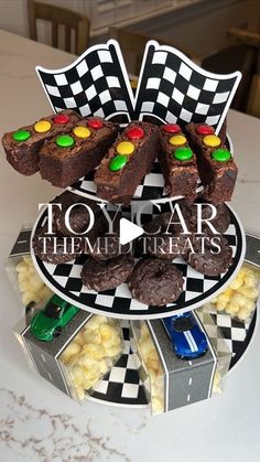 a toy car themed cake on top of a plate with cookies and candies in it