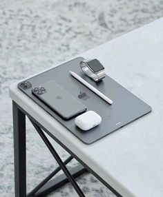 an apple watch, cell phone and other electronics on a table with a gray background