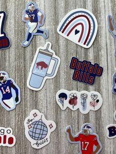 various stickers and decals are displayed on a wooden surface, including football players