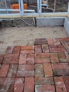 a brick patio being built in front of a window