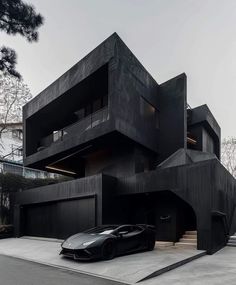 a black sports car parked in front of a large building with multiple levels on the roof