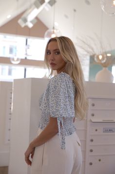 This Floral Smocked Crop Top is the perfect piece for creating a stylish office-to-brunch look. Crafted from delicate floral fabric, this blouse features smocked bodice, puff sleeves, and a ruffle hem for an added touch of luxury. Perfect for pairing with slacks to ace that presentation, or a mini skirt for a day out with friends. white smocked top with blue floral print puff sleeves has stretch ruffle hem true to size 100% polyester machine wash cold model is wearing a medium Chic Short Sleeve Peasant Top With Smocked Back, Spring Short Sleeve Peasant Top With Gathered Sleeves, Feminine Short Sleeve Peasant Top With Smocked Back, Short Sleeve Smocked Top With Smocked Cuffs For Brunch, Chic Smocked Top With Lantern Sleeves For Spring, Chic Smocked Lantern Sleeve Top For Spring, Chic Peasant Top With Smocked Bodice And Short Sleeves, Brunch Peasant Top With Smocked Bodice, Elegant Smocked Top For Day Out