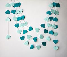 paper hearts hanging from strings on a wall