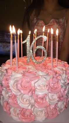 a birthday cake with pink roses and candles