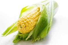 an ear of corn is shown on a white surface