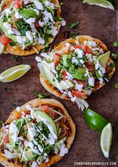 three tacos topped with avocado, sour cream and cilantro