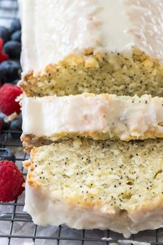 a loaf of lemon poppy seed bread on a cooling rack with raspberries and blueberries