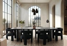 an elegant dining room with black chairs and a large table in front of two arched windows