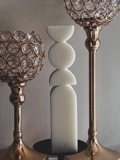 three gold and white vases sitting on top of a table