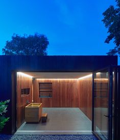 an open room with wooden walls and lighting on the ceiling is lit up at night