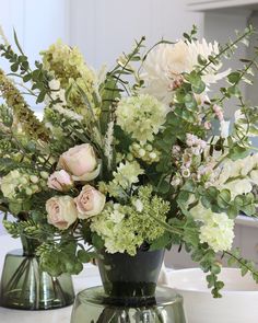 two vases filled with flowers on top of a table