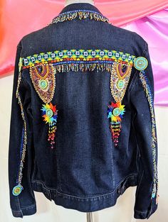 a denim jacket with colorful beading on it