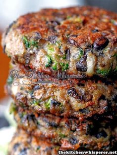 three burgers stacked on top of each other with lettuce in the foreground