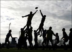 a group of people playing with a frisbee on a field in the evening