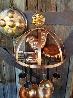 a metal rack with pots and pans hanging from it's sides on a wooden wall