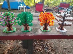 three trees made out of legos on a picnic table