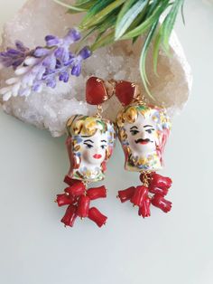 Earrings with dark brown heads in Caltagirone ceramic made and painted by hand, 3 cm in size, with cluster of pink/bamboo red coral flowers. Closing with pink/red cat eye quartz in brass. Hand Painted Red Elegant Earrings, Unique Red Enamel Earrings, Elegant Hand Painted Red Earrings, Red Cat Eye, Brown Earrings, Ceramic Earrings, Coral Flowers, Ceramic Earring, Red Cat