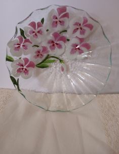 a glass plate with pink and white flowers on it