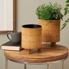 two wooden planters sitting on top of a table next to a book and coffee cup