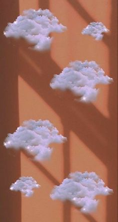 the shadow of clouds is cast on an orange wall