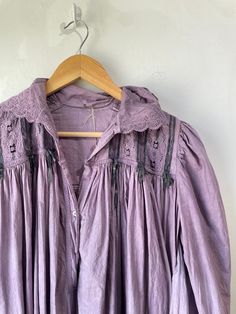 Vintage Victorian Overdyed Purple Dress. Lace-trimmed dress with bow details and puffy sleeves that make you feel like you're in a haunted 1920s mansion. The collar has black details that bring out the lacey designs. In good vintage condition with a few missing buttons (sold as is). Fits like a S/M. Feels like cotton/linen. Approx. Measurements: Underarm to underarm: 18" Length: 55" Long Sleeve Lace Trim Dress For Night, Long Sleeve Dresses With Lace Trim For Night, Vintage Victorian Dress With Lace Collar And Long Sleeves, Long Sleeve Cotton Victorian Dress With Lace Trim, Cotton Victorian Dress With Lace Trim, Long Sleeve Victorian Cotton Dress With Lace Trim, Victorian Dress With Lace Trim And Long Sleeves, Vintage Lace Trim Dresses For Loungewear, Daywear Victorian Dress With Lace Patchwork