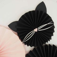 black paper fans with pink and white flowers on the top one has a heart in it