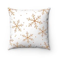 a white pillow with gold snowflakes on it