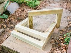 a wooden bench sitting on top of a pile of wood next to a brick walkway