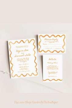 the wedding stationery is set up on top of each other, with an orange and white border