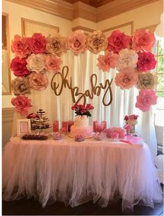 a table topped with pink and white flowers next to a sign that says baby on it