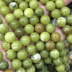 a hand holding a bunch of green beads