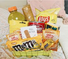 a basket filled with snacks and drinks on top of a bed