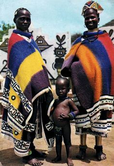 two men and a baby standing in front of a building