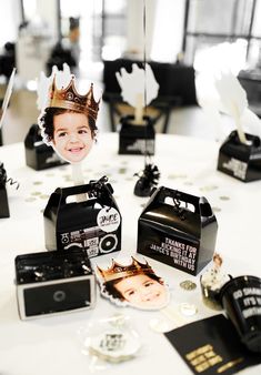 a table topped with black and white boxes filled with items to make a photo booth