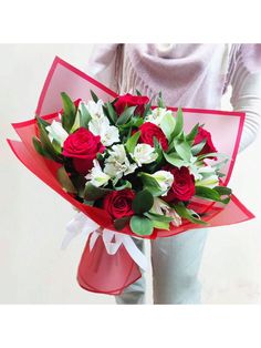 a woman holding a bouquet of red and white flowers