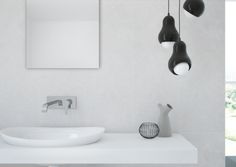 a bathroom with two sinks and three hanging lights