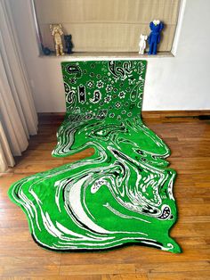 a green area rug sitting on top of a hard wood floor next to a window