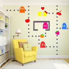 a living room with pacman wall decals on the walls and a yellow chair