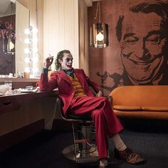 a man dressed as the joker sitting in a chair