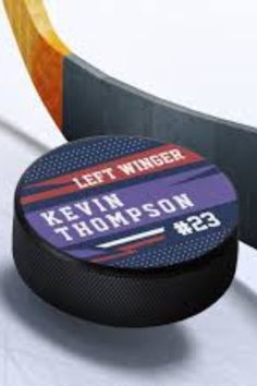 a hockey puck sitting on top of an ice rink next to a sign that says let winter kevin thompson