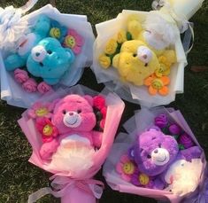 four teddy bears are wrapped in plastic and sitting on the grass with ribbons around them