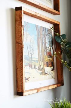 a painting hanging on the wall next to a potted plant