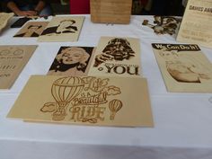 several wooden cards are sitting on a table with white linens and paper cutouts