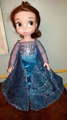 the doll is wearing a blue dress with sequins