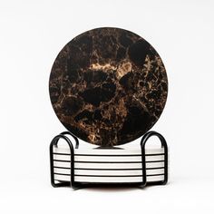 a black and white marble plate sitting on top of a metal stand