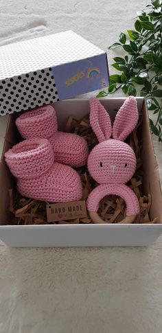 a pink knitted bunny and booties in a box