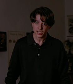 a young man in a black shirt is making a face