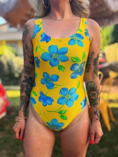 Super cute high cut vintage 80s/90s Catalina bright yellow one piece with blue tropical flowers + scoop back! No issues!  Measured flat while resting: Pit to pit: 19" Waist: 14" Hip: 15" Length: 26" For reference I am 5'4" and measure 34/28/38" and this fit me everywhere but loose on the chest. LMK if you have any questions! Yellow Surfing Swimwear For Summer, Yellow Bodysuit For Beach Party, Yellow Beach Party Bodysuit, Yellow Bodysuit For Beach Season Sunbathing, Yellow Bodysuit For Sunbathing At Beach Season, Yellow Sleeveless Bodysuit For Sunbathing, Fitted Yellow Bodysuit For Sunbathing, Yellow Printed Bodysuit For The Beach, Retro Yellow Swimwear For Sunbathing