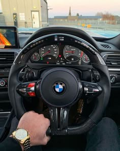 a man is driving his bmw car on the road