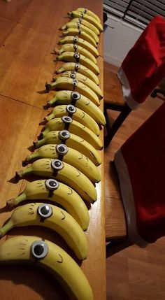 a long row of bananas with faces drawn on them and santa's hat in the background